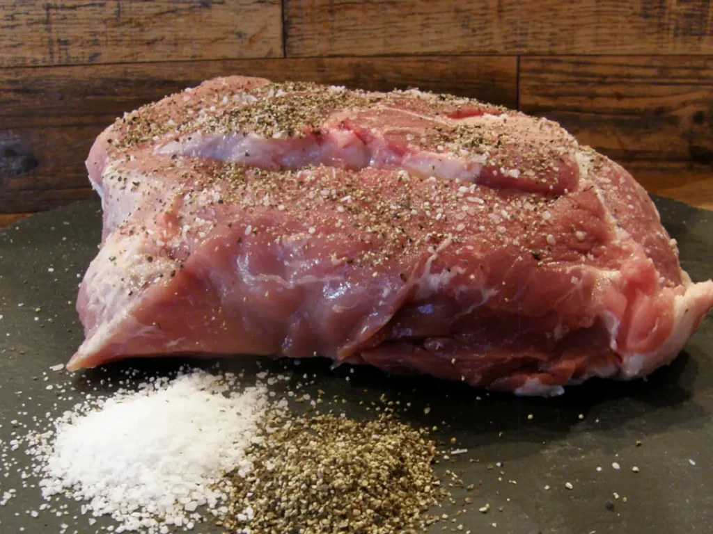 raw pork roast with salt and pepper